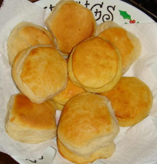some golden brown rolls are on a white plate