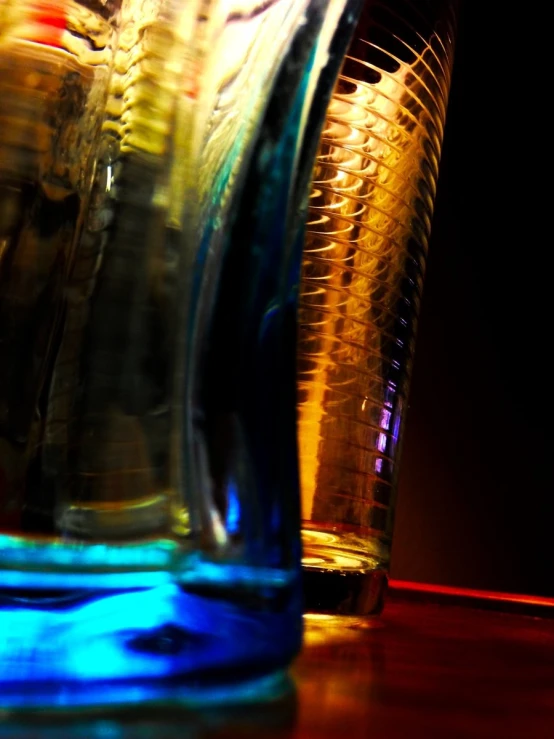 a table topped with two glasses next to a bottle