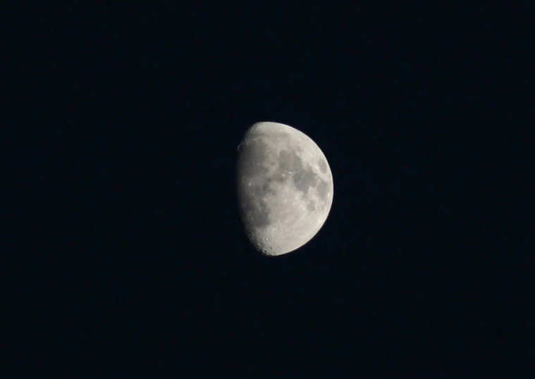 a half moon is lit up in the night sky