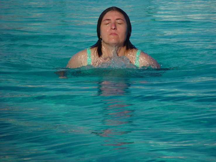 a woman is submerged in the clear blue water