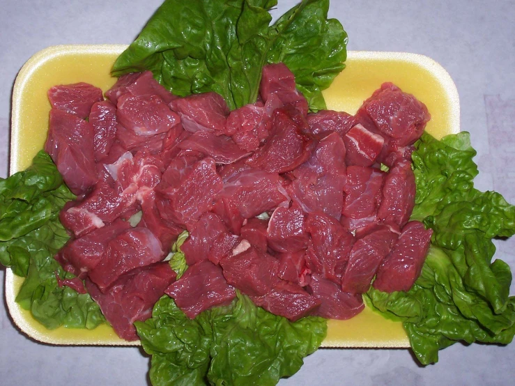 a platter with spinach and meat on it