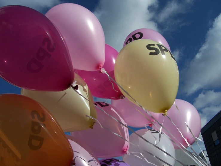 a bunch of balloons floating from a sky with the word sale in the center