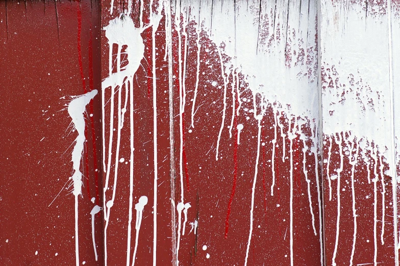 white paint dries down a red wall and ceiling