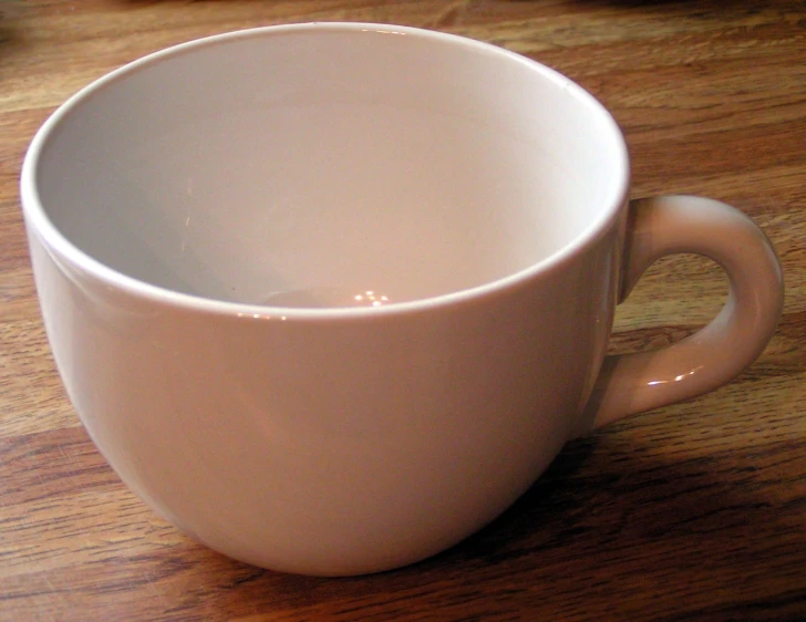 this is an empty coffee cup on a wood table