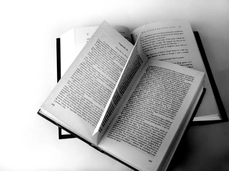 three book open to pages that are in black and white