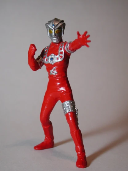 an action figure with a helmet on wearing a red uniform