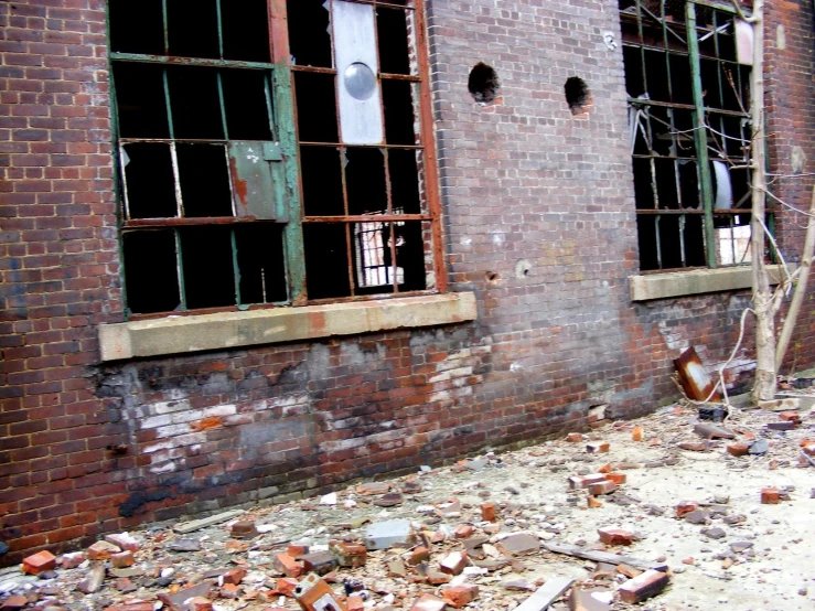 some broken down windows in an old brick building