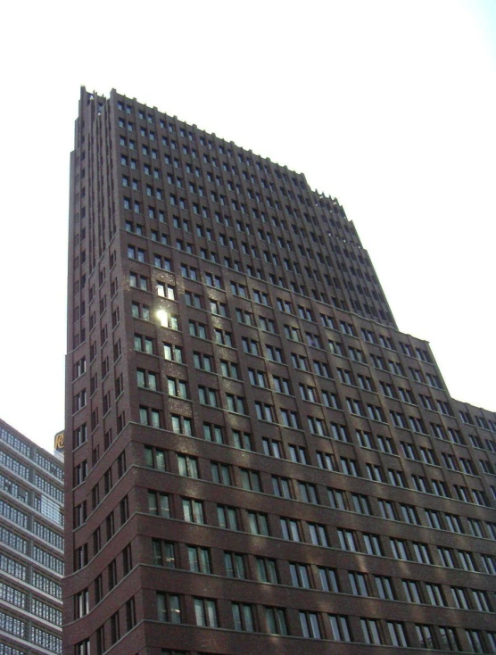 a tall brown building with several windows on top