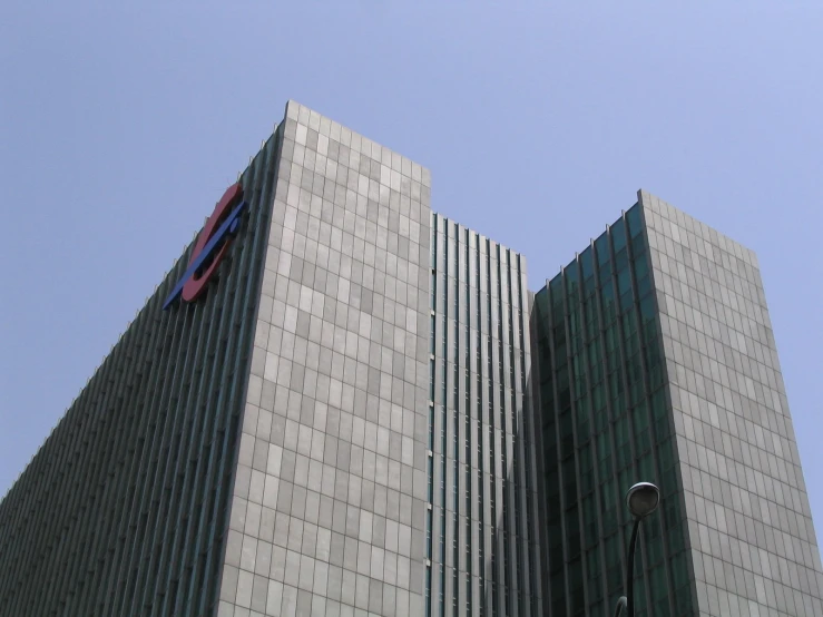 a tall white building is next to another tall gray building