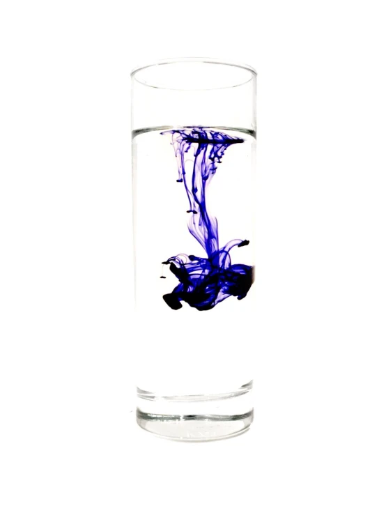 a glass with blue ink floating in it