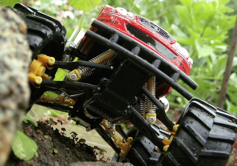 a toy car with multiple wheels in the forest