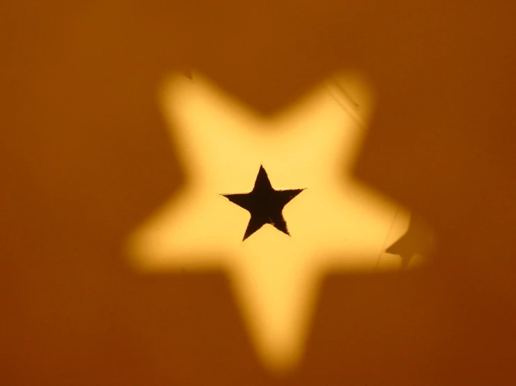 a star is reflecting on a yellow background