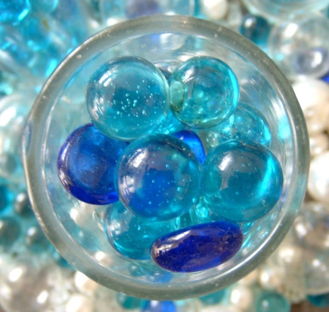 many balls are sitting in a blue glass bowl