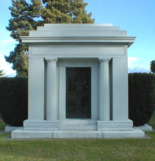 a white monument in a field that says holes