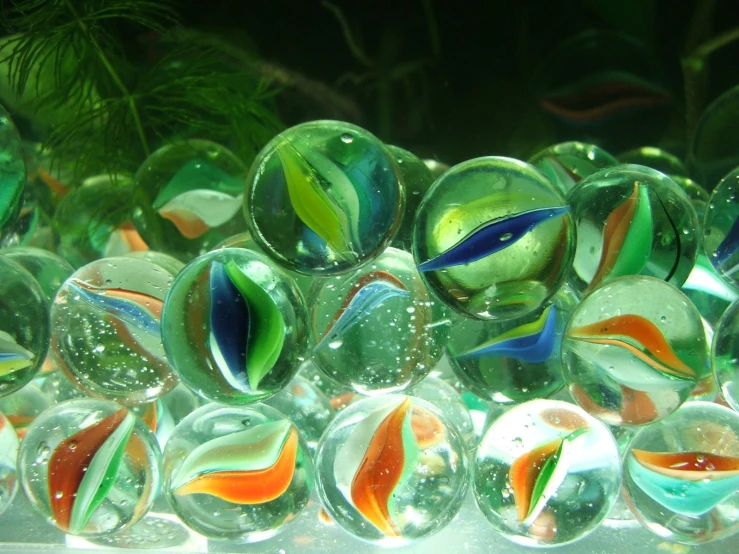 many colorful balls sit in an aquarium tank