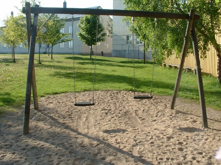 the playground in a back yard with a swing set