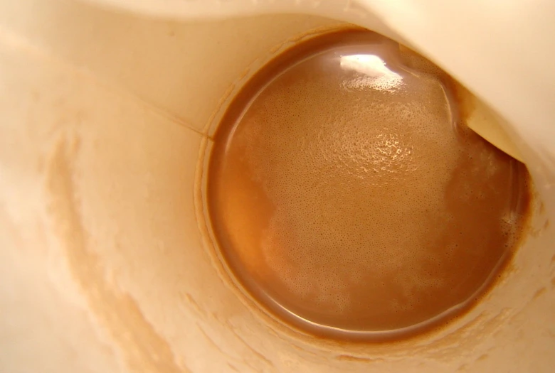 a brown liquid pouring into a white bowl