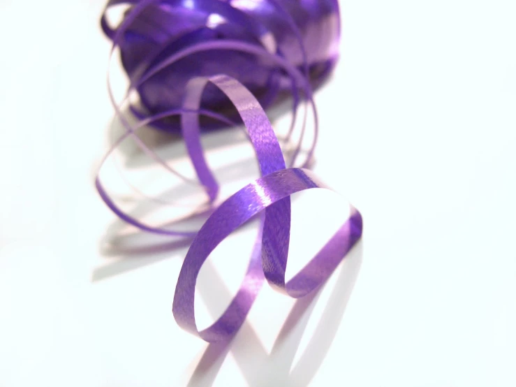 a purple ribbon on a white table