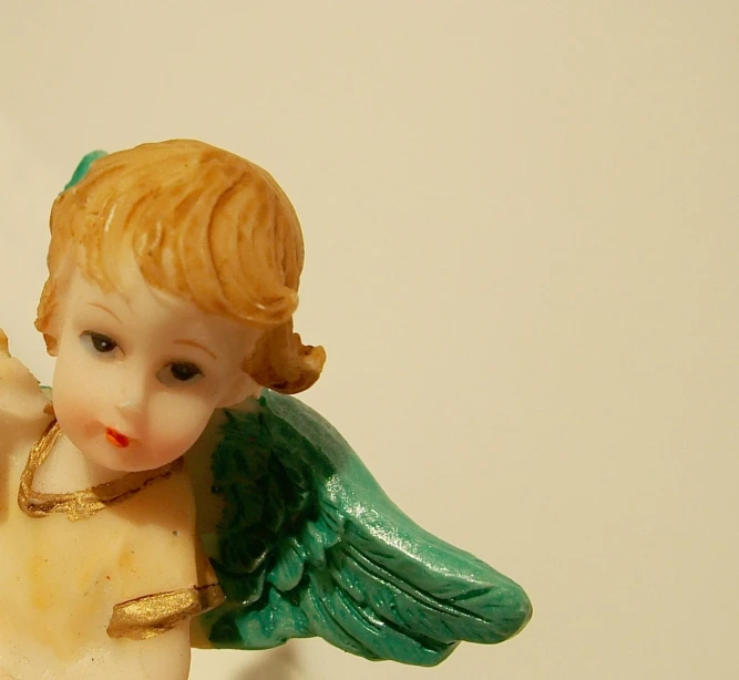 an angel figurine with golden hair and a green scarf