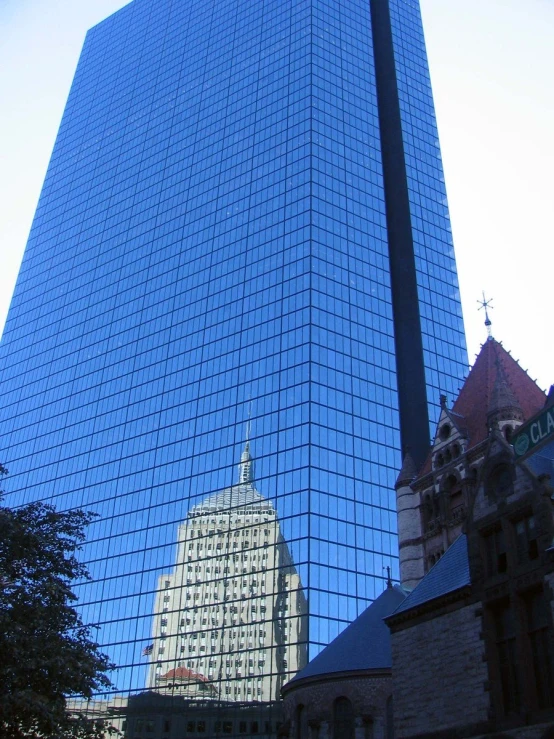 the side of a tall building and reflection in it