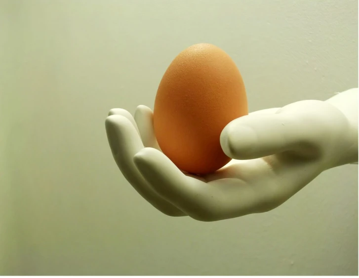 the hand is holding an egg that's shaped like a glove