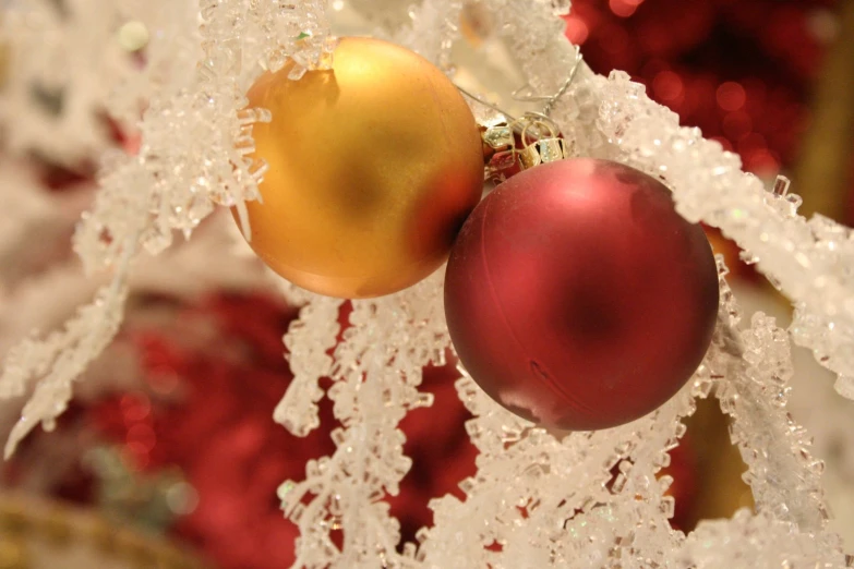 two christmas ornaments on some lacy plastic