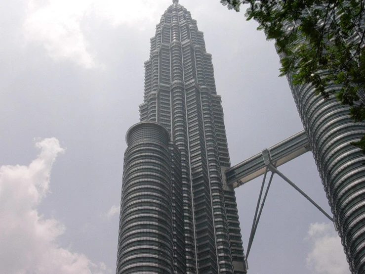 some very tall buildings against a cloudy blue sky