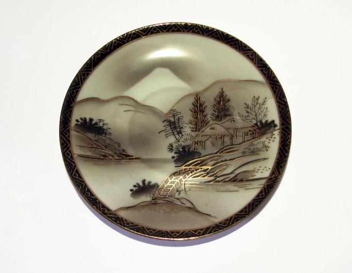 a decorative plate that has a landscape on it