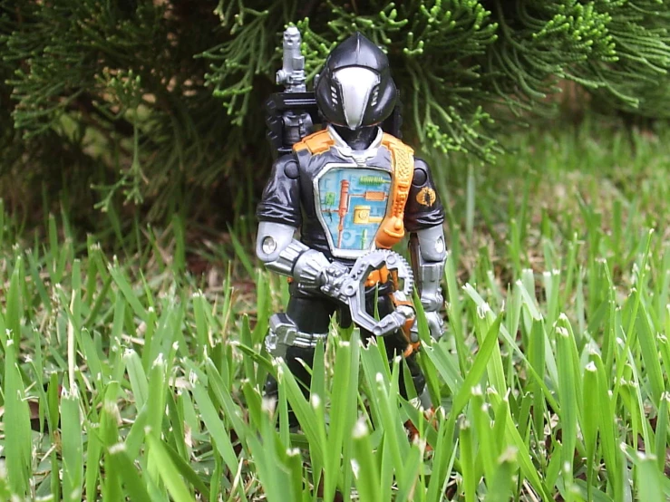 the action figure is standing in some tall grass