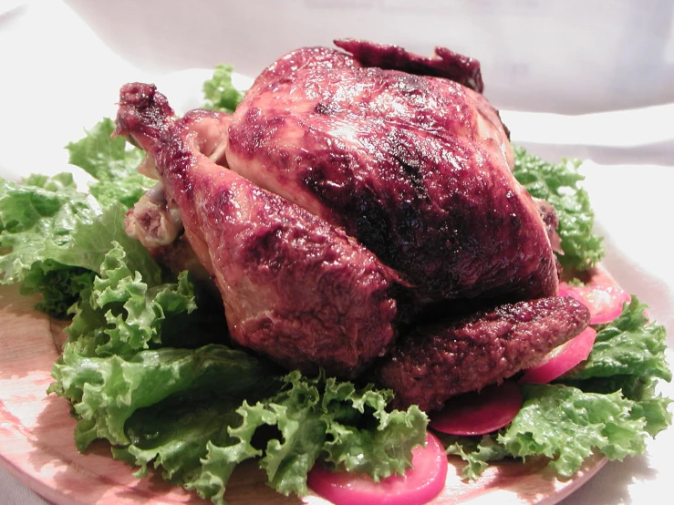 a roasted chicken sits on a green leafy salad