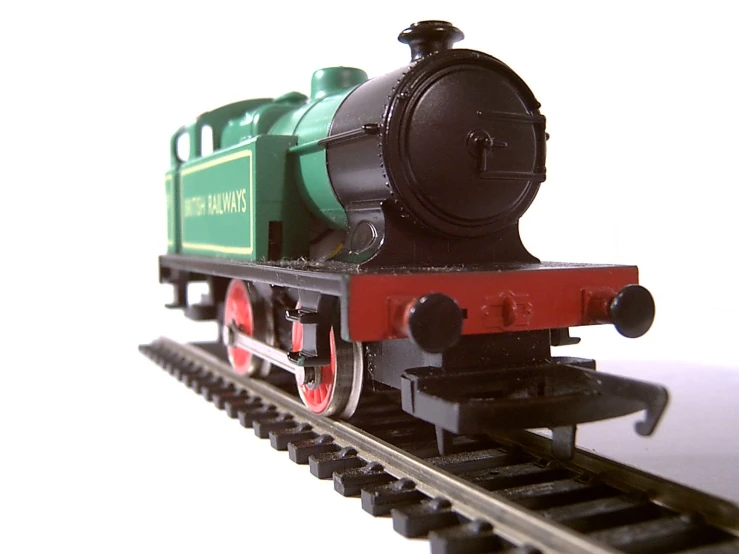 a small green and black train on tracks
