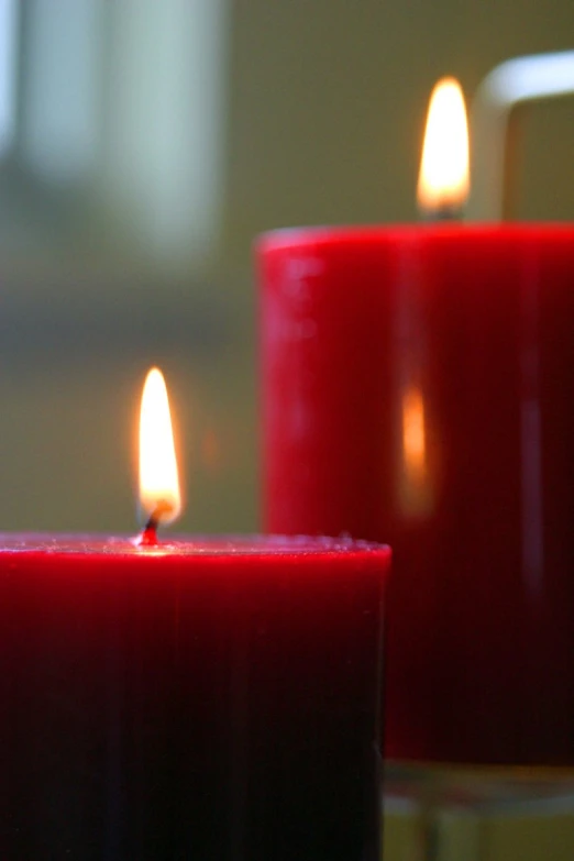 three red candles burn brightly in the candlelight