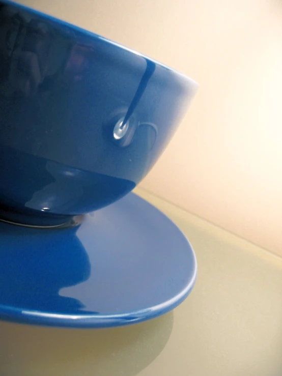 a blue bowl on a plate on a table