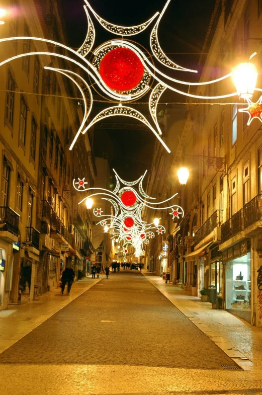 an old city street is lit up with christmas lights