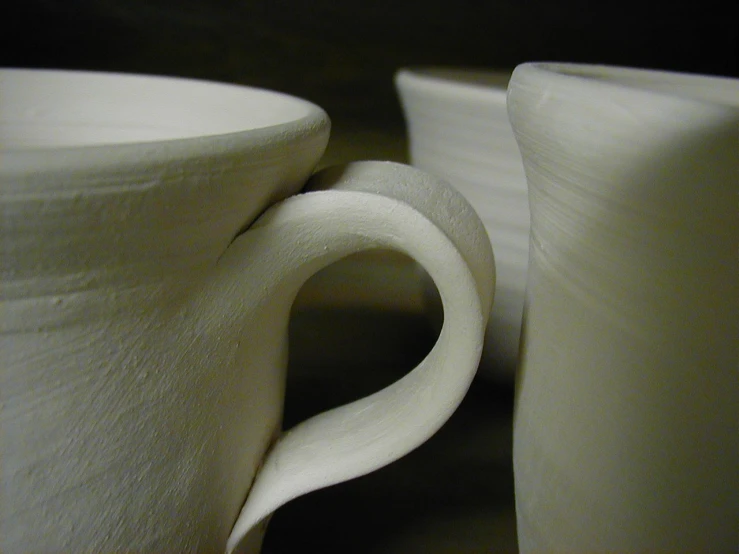 an image of white ceramic vases with curves