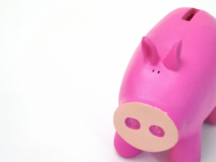 a pink pig toy on a white surface