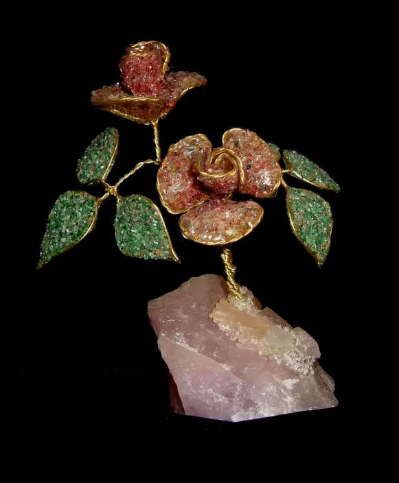 a brooch on top of a rock with flowers