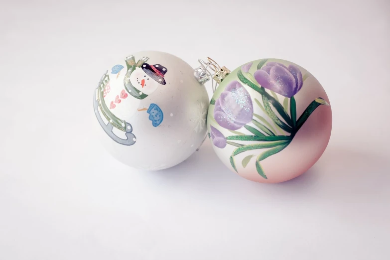 two christmas balls one with some drawings on it