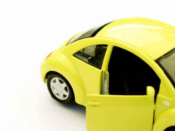 the toy car is bright yellow with its door open