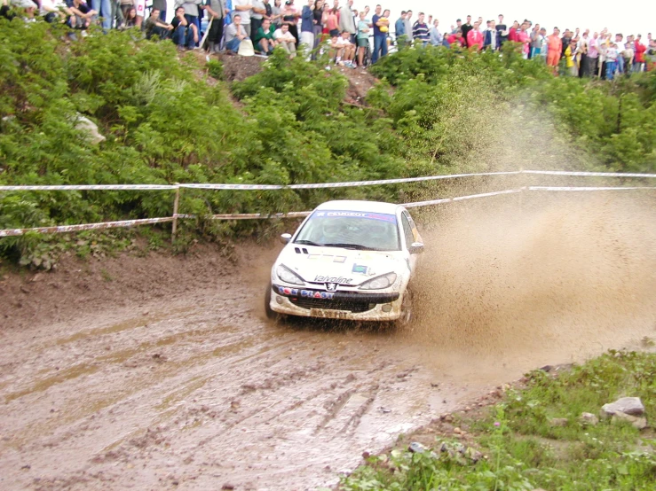 two cars driving through the mud at a rally