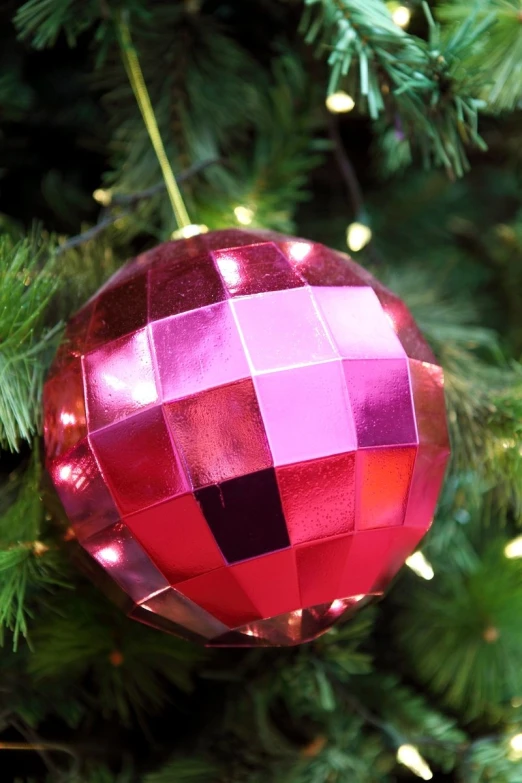 a very pretty colorful christmas ornament hanging from a christmas tree