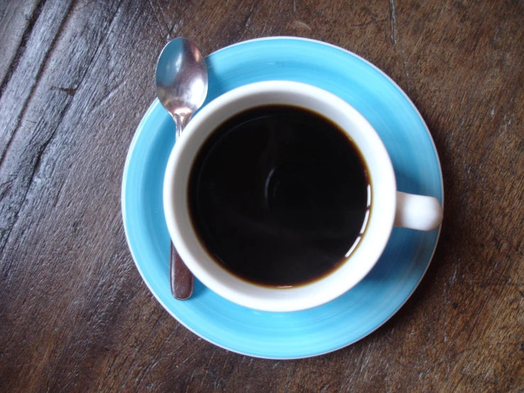 a blue cup with liquid on top of a saucer