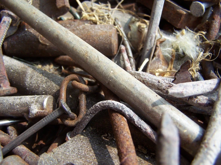 a group of rusty chains and tools are piled together
