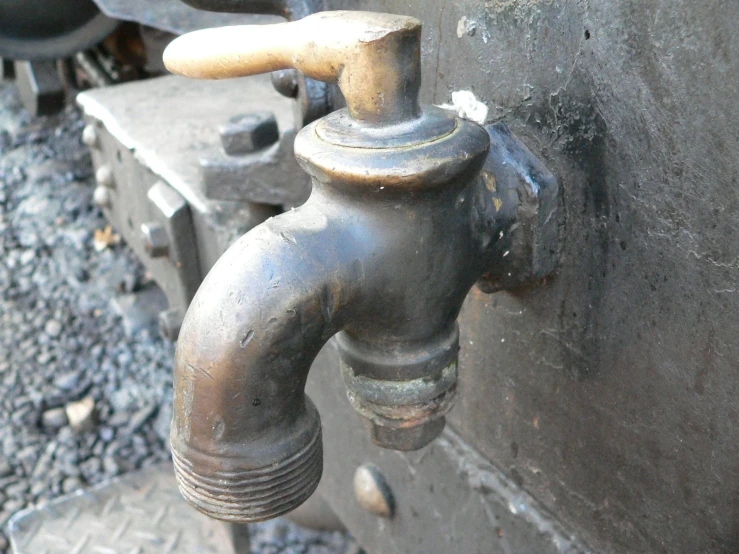 a close - up of an old faucet near a wall