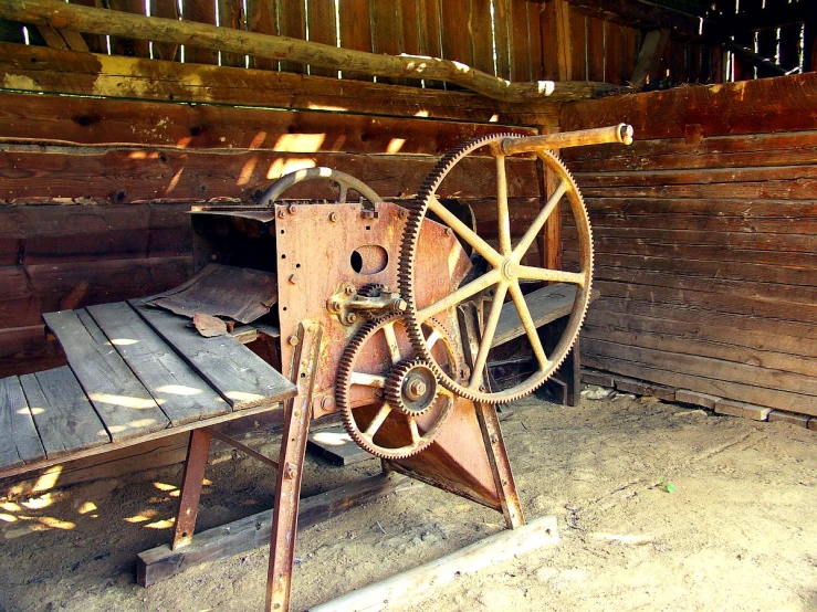 old machinery is in front of an old wood structure