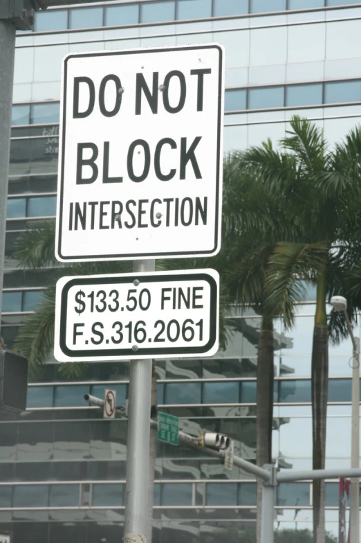 two street signs on metal poles outside a business