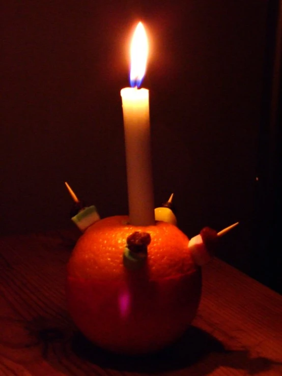 a candle in an apple is sitting on a table