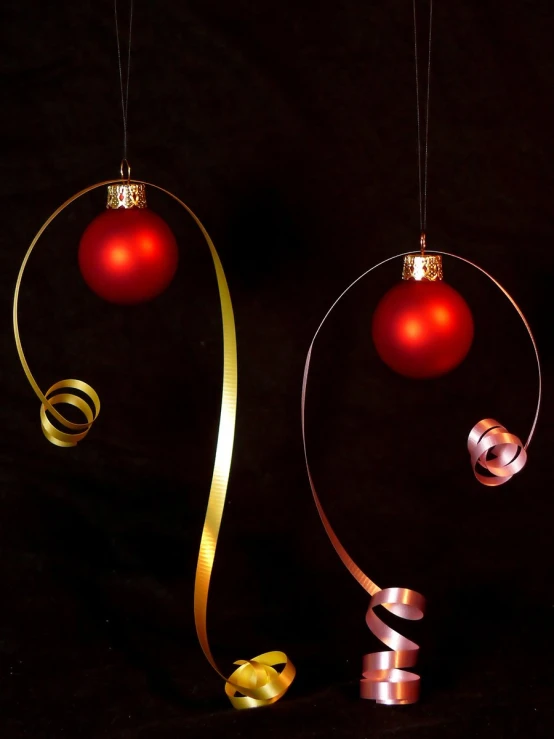 two hanging ornaments sitting next to each other