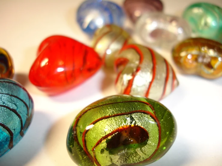 six glass vases with striped designs and a round opening