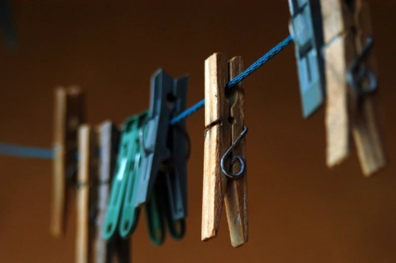 clothes pegs and a wooden pole hold scissors